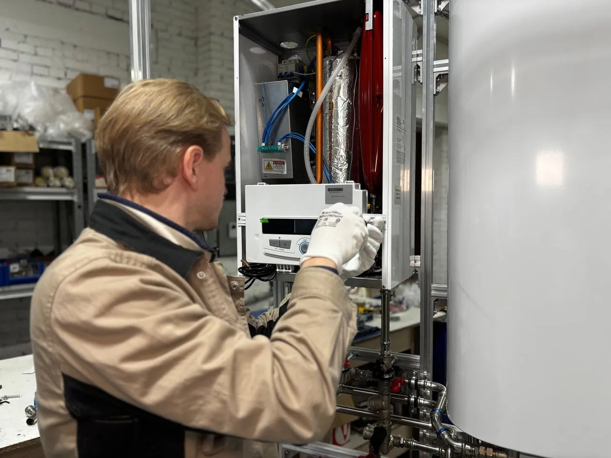 Technician working on a wall-mounted heating unit